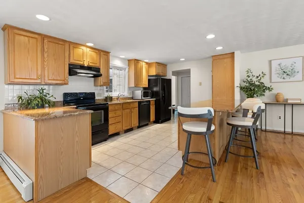 a kitchen with stainless steel appliances a stove a sink a microwave a dining table and chairs