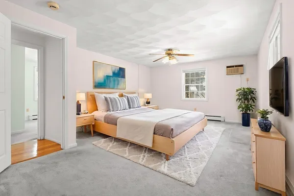 a spacious bedroom with a bed and a flat screen television
