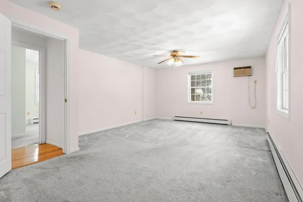 an empty room with windows and fan