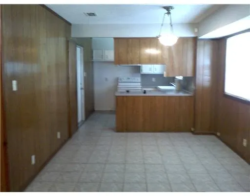 a view of kitchen with granite countertop cabinets and chandelier