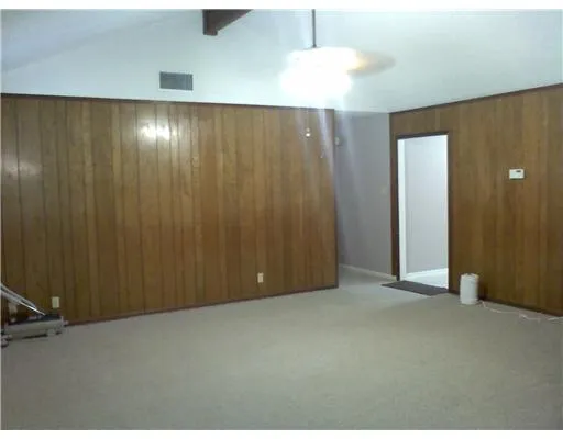 an empty room with a ceiling fan and a chandelier fan