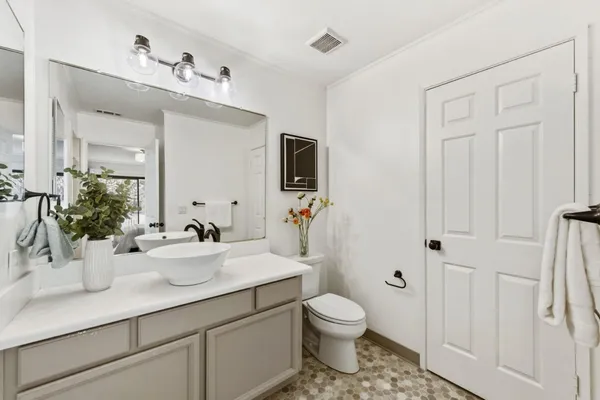 a bathroom with a sink a toilet and mirror