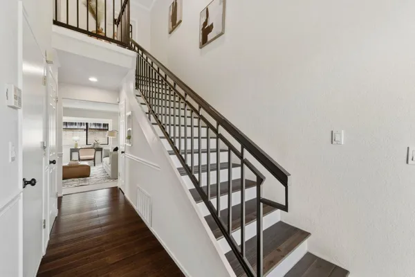 a view of staircase with wooden floor and white walls