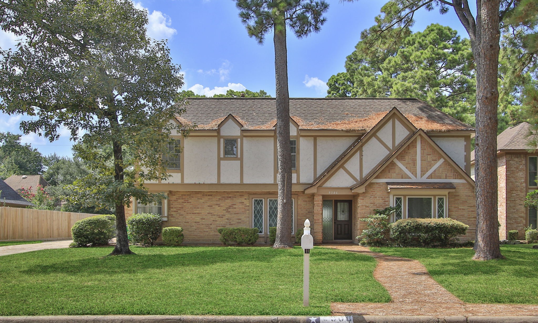 a front view of a house with a garden and yard