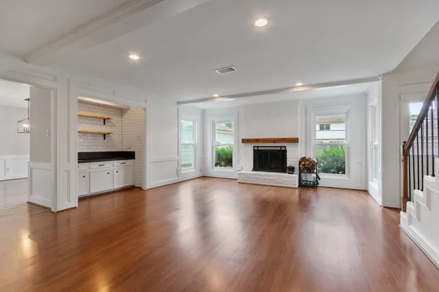 a view of empty room with fireplace and wooden floor