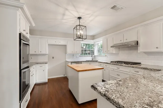 a kitchen with white cabinets and appliances