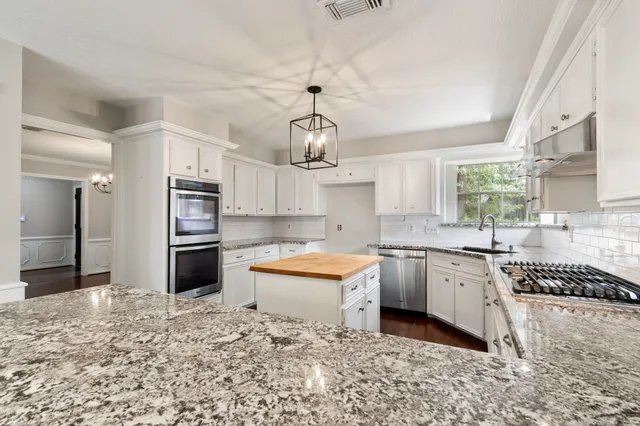 a kitchen with stainless steel appliances granite countertop a sink stove and refrigerator
