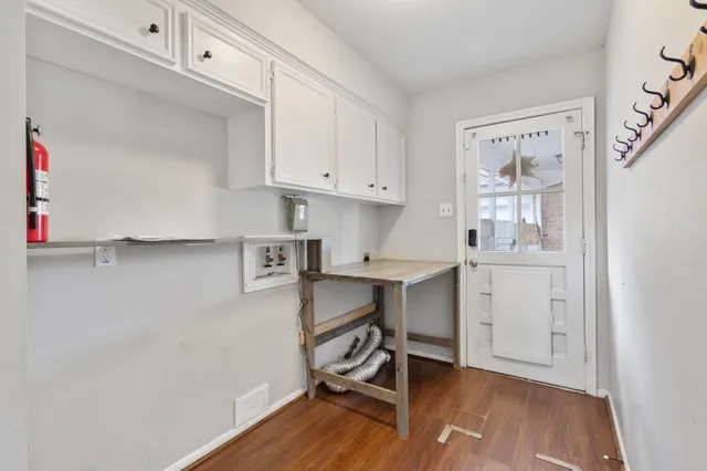 a view of workspace with wooden floor and white cabinet