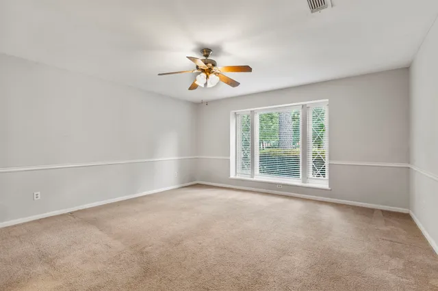 a view of a livingroom with a ceiling fan and window