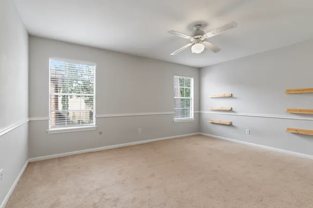 a view of a livingroom with a ceiling fan and window