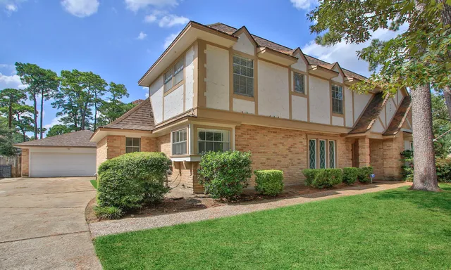 a front view of a house with a garden and plants