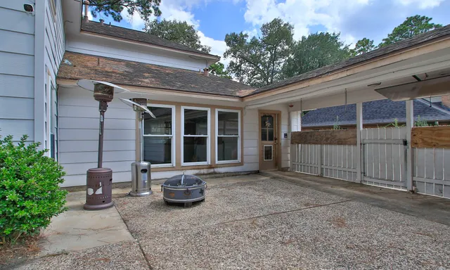 a view of a house with a large window and potted plants