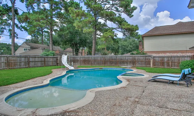 a view of a backyard with swimming pool