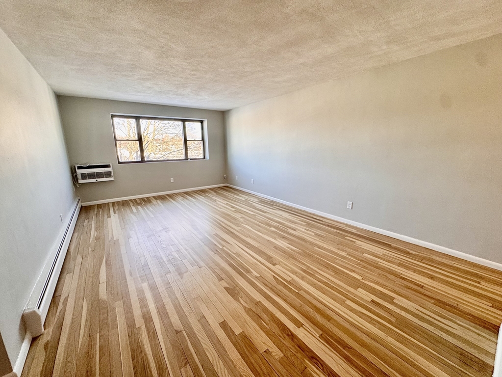 97 Spring Street, Unit C6 Boston, MA 02132 - Photo 3 of 8 wooden floor in an empty room with a window