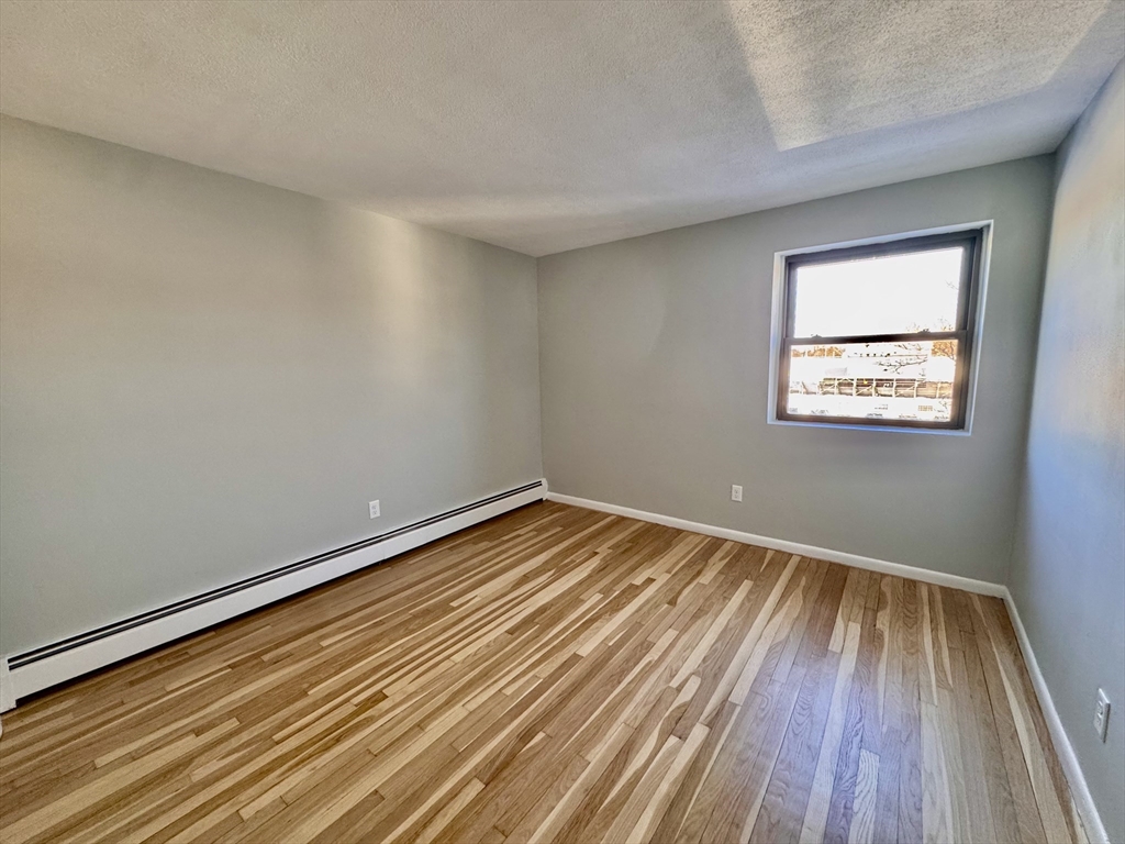 97 Spring Street, Unit C6 Boston, MA 02132 - Photo 4 of 8 a view of a room with wooden floor and window