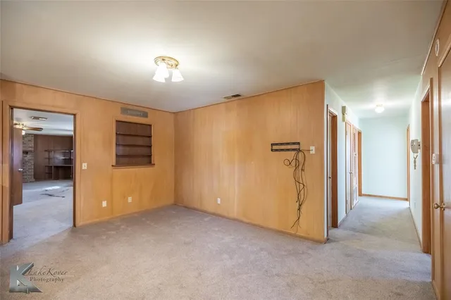 an empty room with closet and a hallway