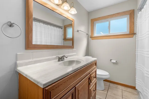 a bathroom with a sink a toilet and a mirror
