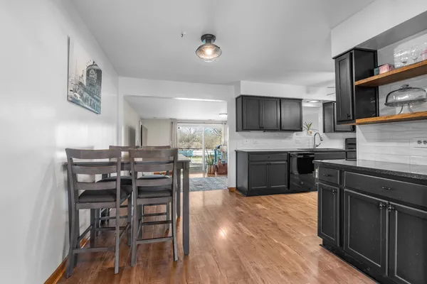 a kitchen with a table chairs microwave and cabinets