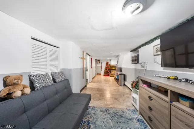 a living room with furniture flat screen tv and a window