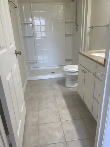 a bathroom with a granite countertop sink toilet and shower