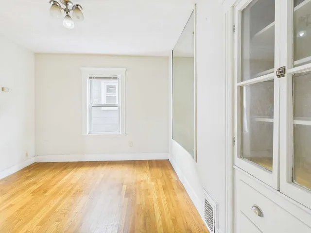 a view of a room with wooden floor and cabinet