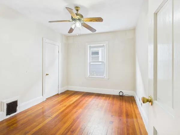 a view of a room with wooden floor and a window