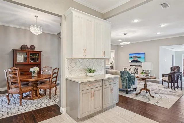 a view of a dining room and livingroom with furniture wooden floor a rug and a chandelier