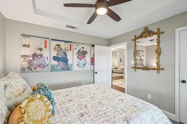 a bedroom with a bed and painting on the wall