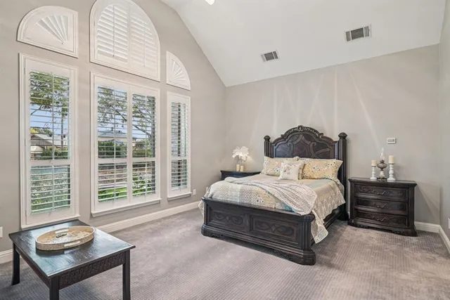 a bedroom with a bed and a large window