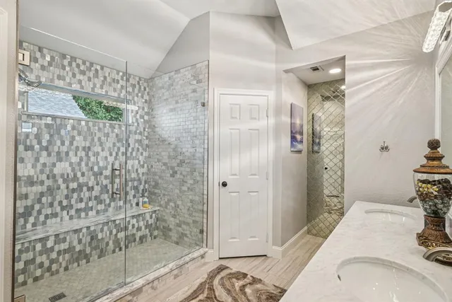 a bathroom with a granite countertop shower a mirror and a sink