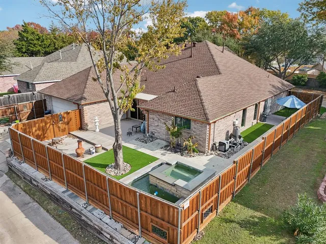 a view of house with roof deck and wooden fence