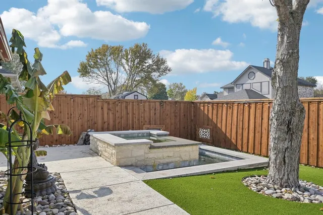 a backyard with table and chairs with wooden fence
