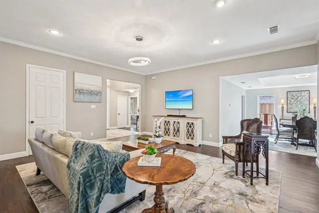 a living room with furniture and a wooden floor