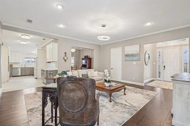 a living room with furniture a wooden floor and a chandelier