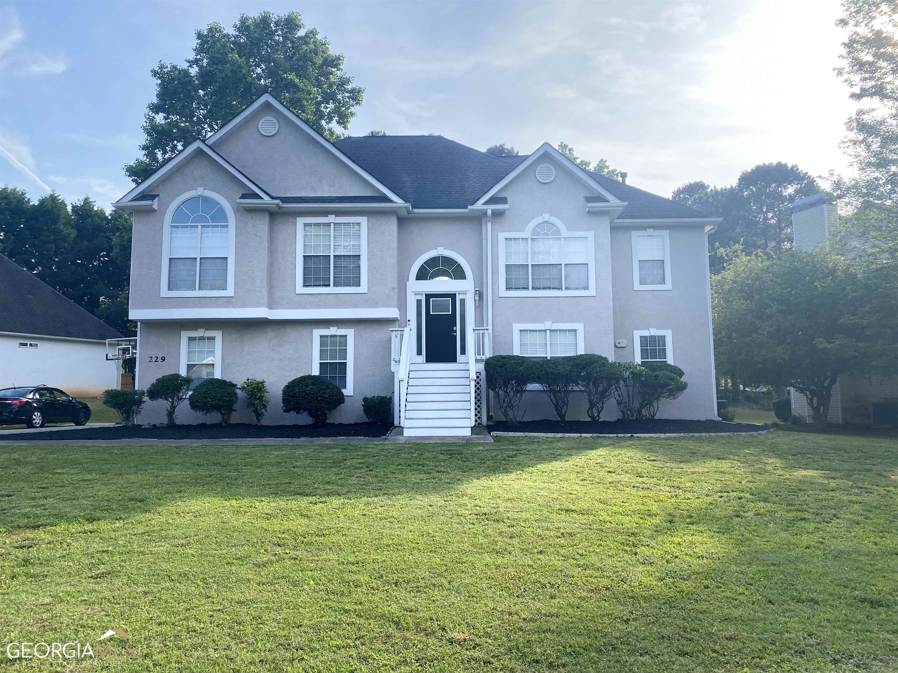 a front view of a house with a garden