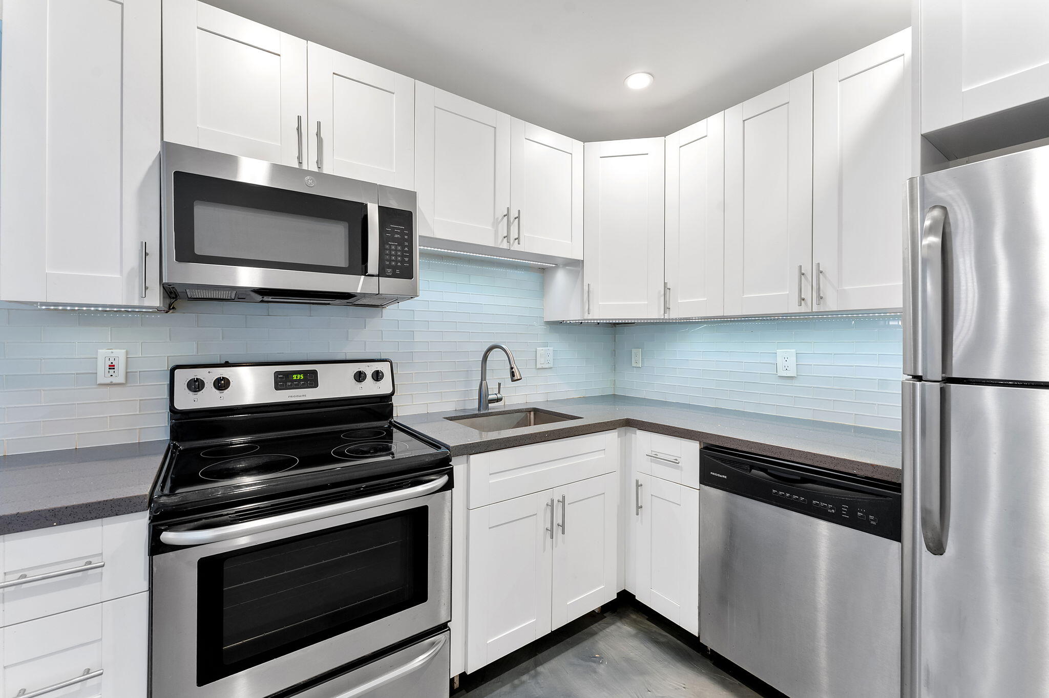 a kitchen with white cabinets and stainless steel appliances