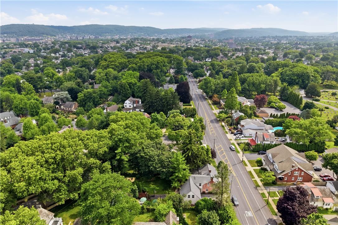 2014 Linden Street Bethlehem, PA 18017 - Photo 81 of 85 An aerial perspective reveals a tree-lined neighborhood with a main road bisecting charming residences, all set against distant hills.