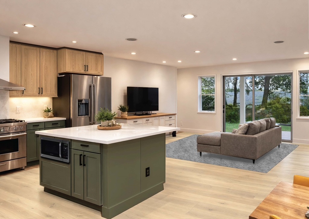 72 Laurel Lane, Unit 2 Lunenburg, MA 01462 - Photo 2 of 18 a kitchen with kitchen island granite countertop a sink and a refrigerator