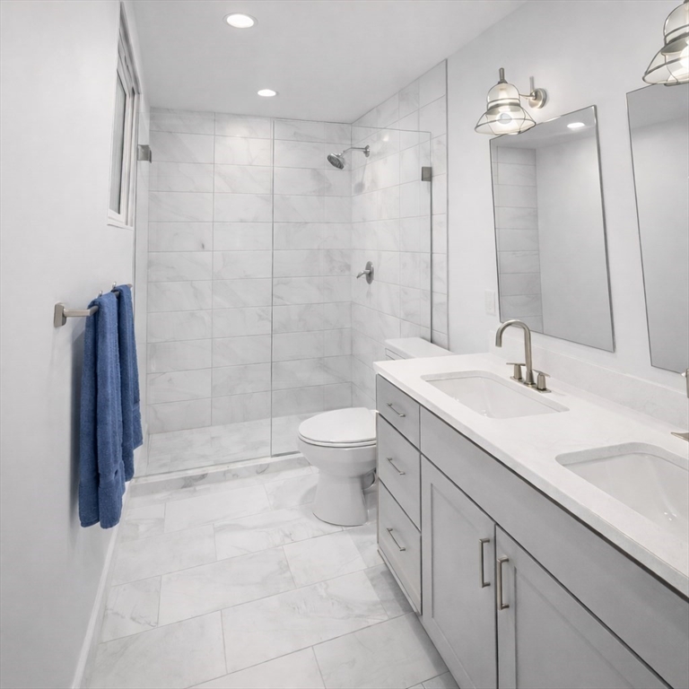 72 Laurel Lane, Unit 2 Lunenburg, MA 01462 - Photo 5 of 18 a bathroom with a double vanity sink toilet and shower