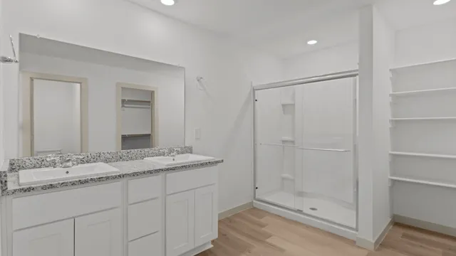 a bathroom with a granite countertop sink a mirror and shower
