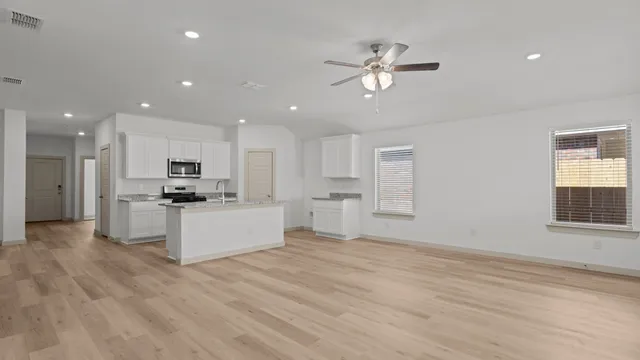 a view of kitchen with kitchen island white cabinets and stainless steel appliances
