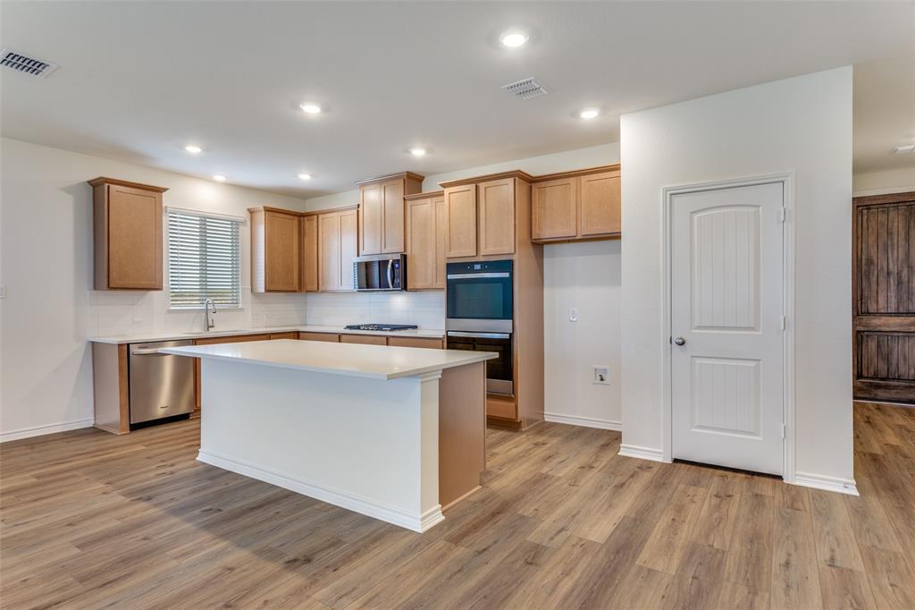 649 Fallbrook Drive Aledo, TX 76008 - Photo 5 of 30 a large kitchen with stainless steel appliances granite countertop a stove a sink and a refrigerator