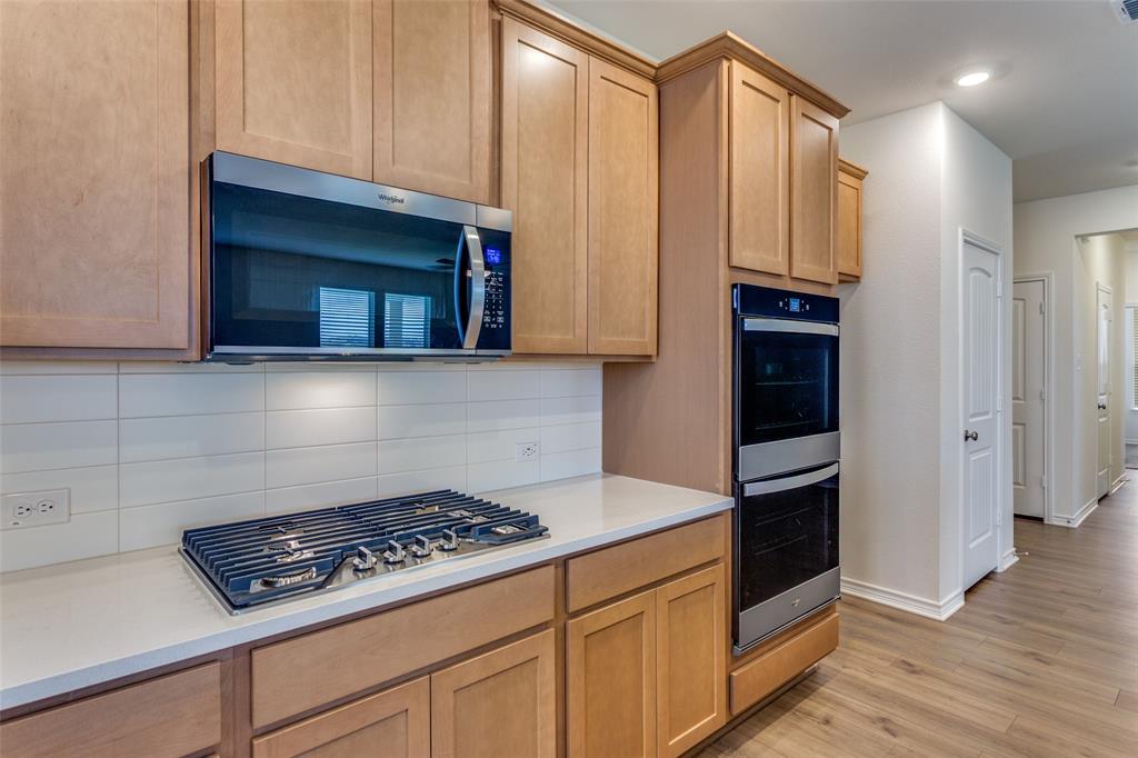 649 Fallbrook Drive Aledo, TX 76008 - Photo 6 of 30 a kitchen with granite countertop a stove and a microwave