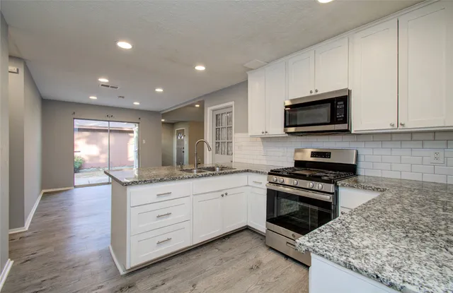 a kitchen with granite countertop a stove and a sink