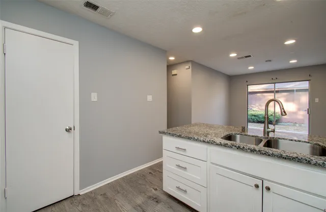 a bathroom with a granite countertop sink and mirror