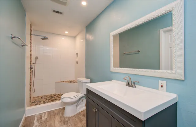 a bathroom with a sink a toilet and shower