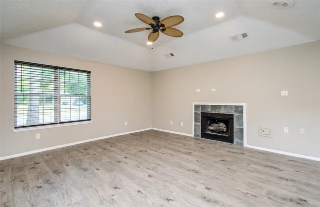 an empty room with fan and windows