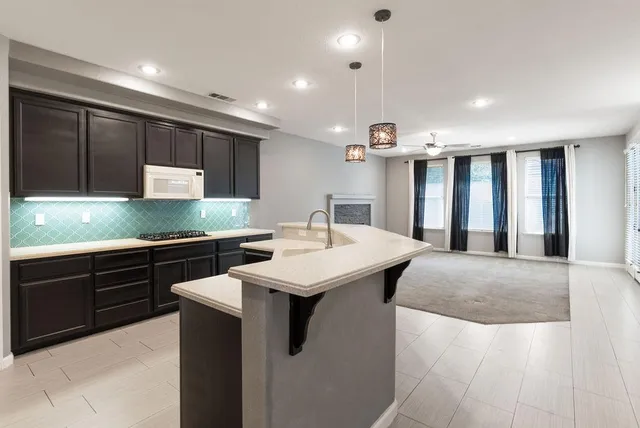 a view of a livingroom with a fireplace and a kitchen