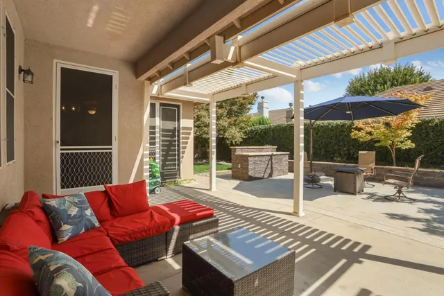 a view of a patio with a table and chairs under an umbrella