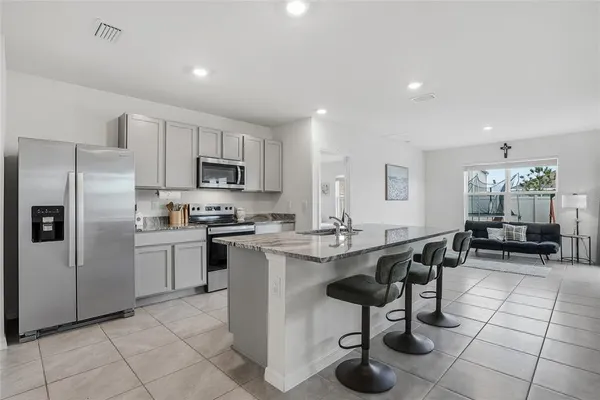 a kitchen with stainless steel appliances granite countertop a refrigerator and a stove top oven